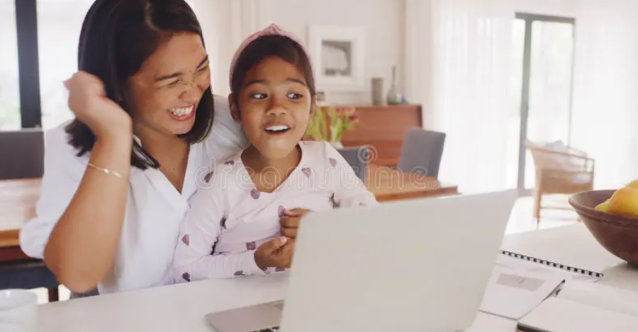 Parent and child learning together on a laptop at home